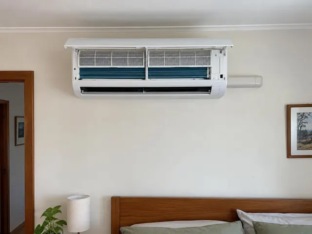 Clean split system with open front panel and visible filters above a bed in a home interior in Para Hills
